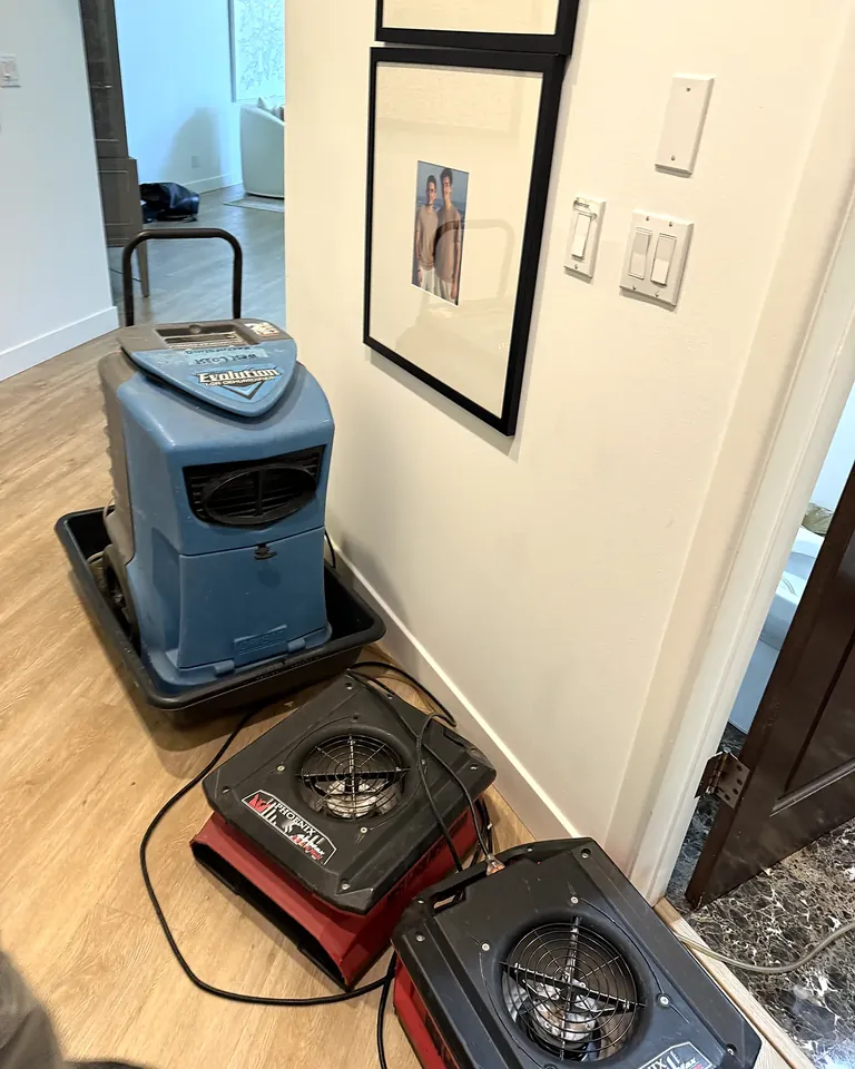 Dehumidifier and air movers drying a commercial building hallway