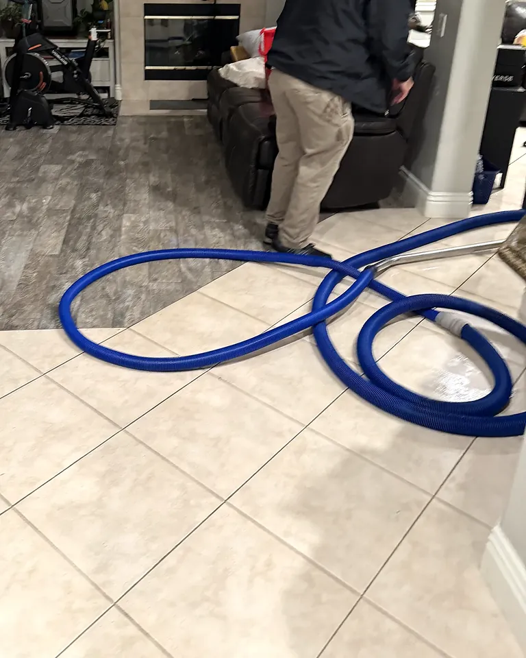 Water extraction hose set up in a living room after a leak