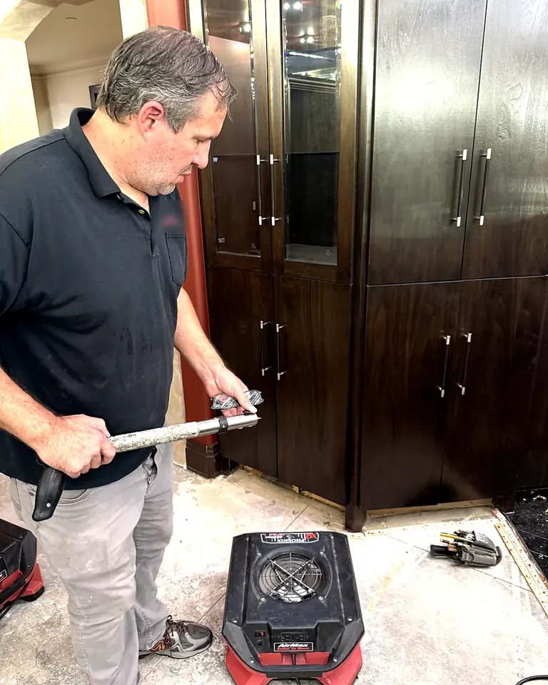Technician removing water-damaged flooring