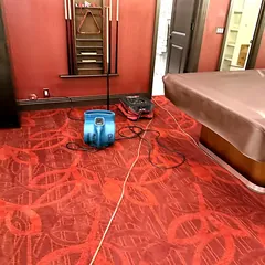 Air mover drying wet carpet in a game room