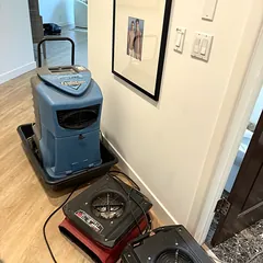 Dehumidifier and air movers drying a commercial building hallway