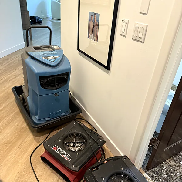 Dehumidifier and air movers drying a commercial building hallway