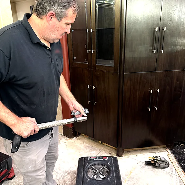 Technician removing water-damaged flooring
