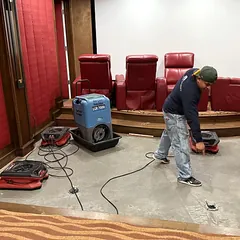 Flood Pro technicians drying a flooded home theater with a commercial dehumidifier and air movers