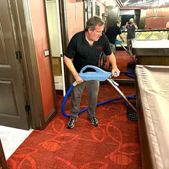 Technician extracting water from wet carpet in a flooded game room