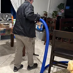 Technician removing standing water from a kitchen tile floor