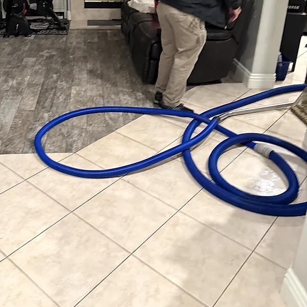 Water extraction hose set up in a living room after a leak